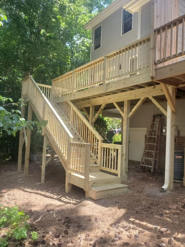 Newly built elevated pressure-treated deck with stairs on a two-story home